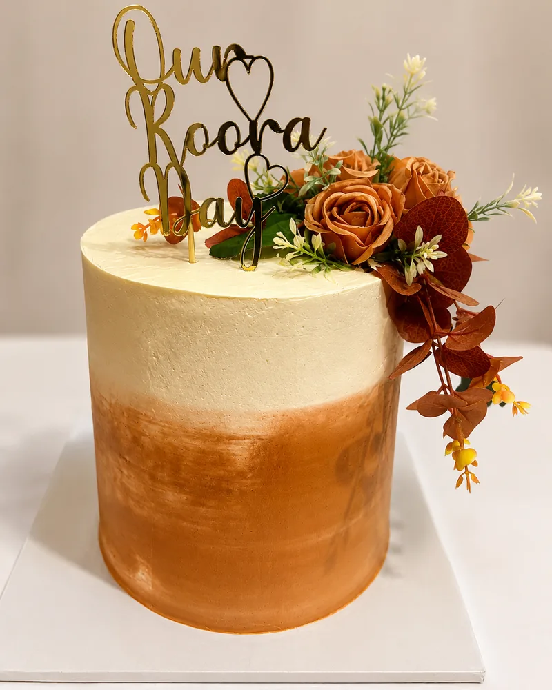 A cream to terracotta ombre Roora Day cake with rust roses, eucalyptus and a gold Our Roora Day topper, by The Cake Studio Harare